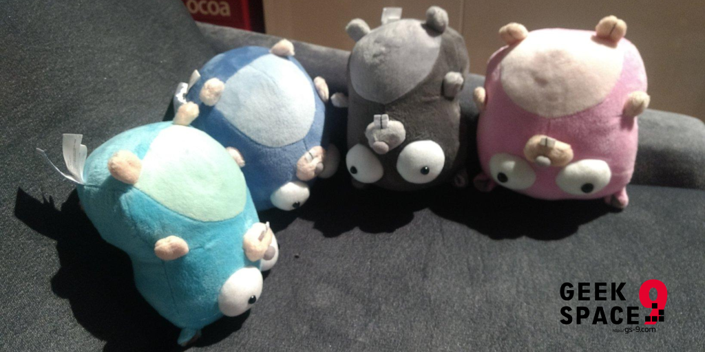 4 gopher plushes sitting upside down on a couch, light blue one, dark blue one, gray one, pink one